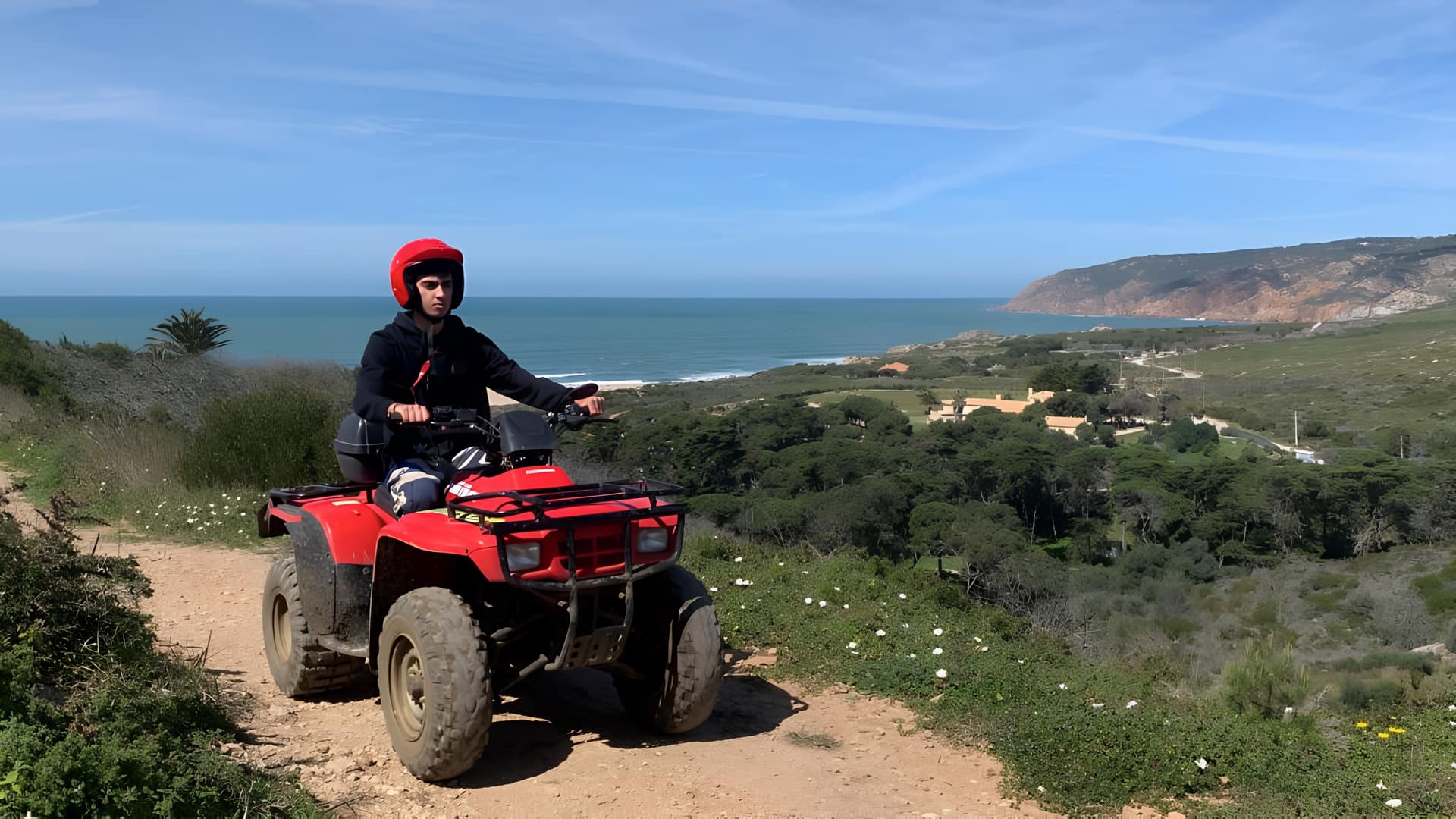 Rider on a red quad bike above the Guincho coast