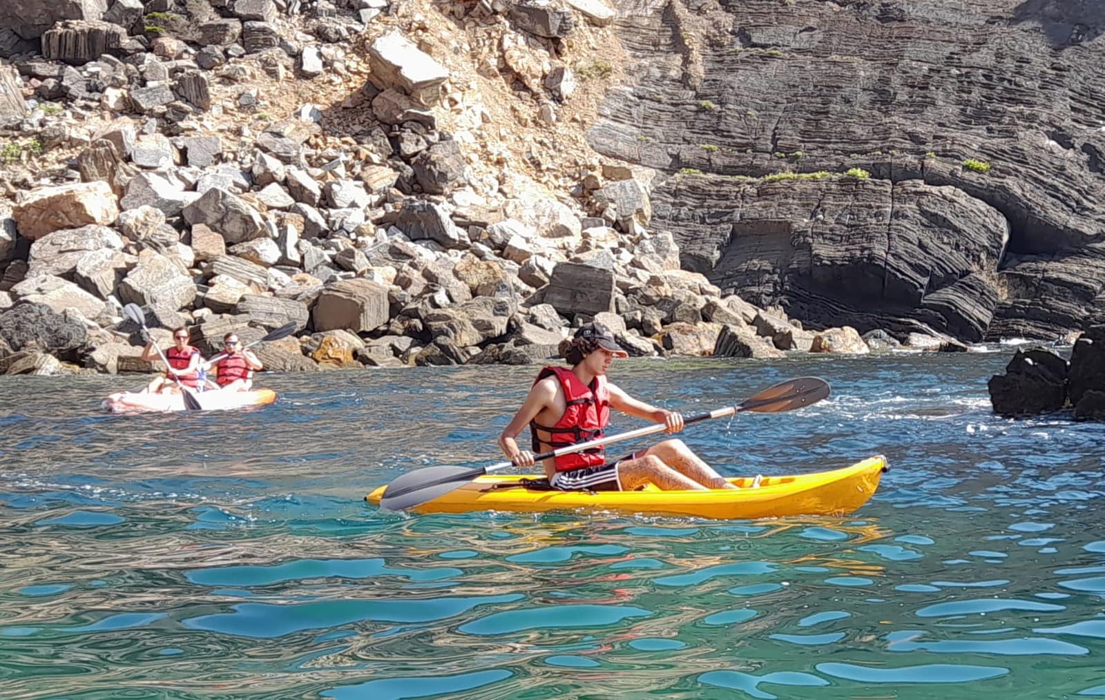 Sea kayakers paddling in a rocky cove of the Atlantic coast